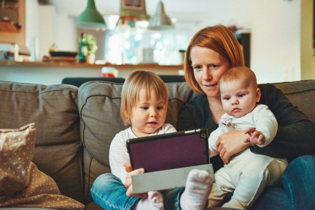 Dos bebés y una mujer mirando YouTube en un iPad